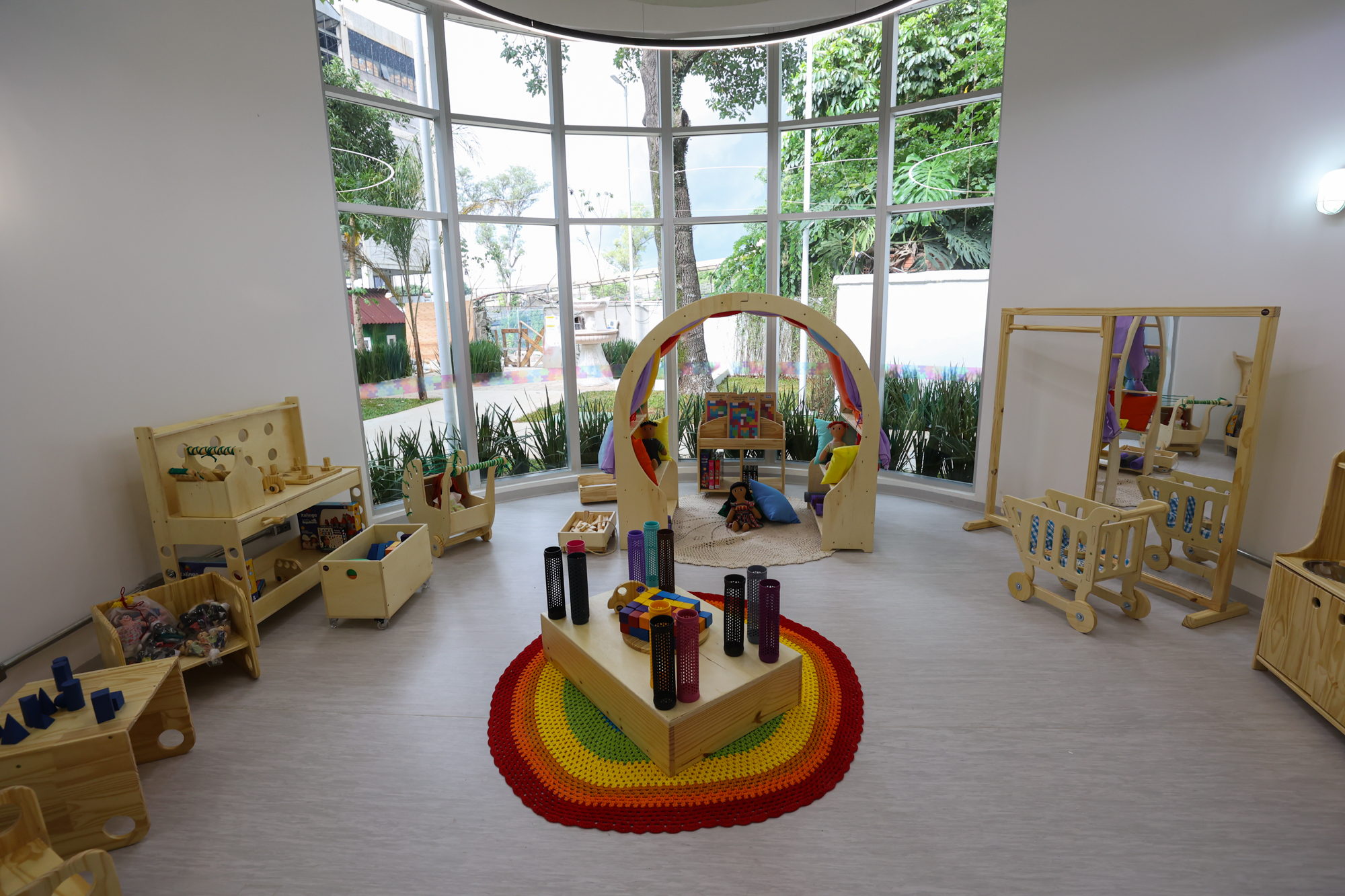 Imagem da brinquedoteca do Centro TEA. Uma sala arredondada com objetivos educativos de madeira.