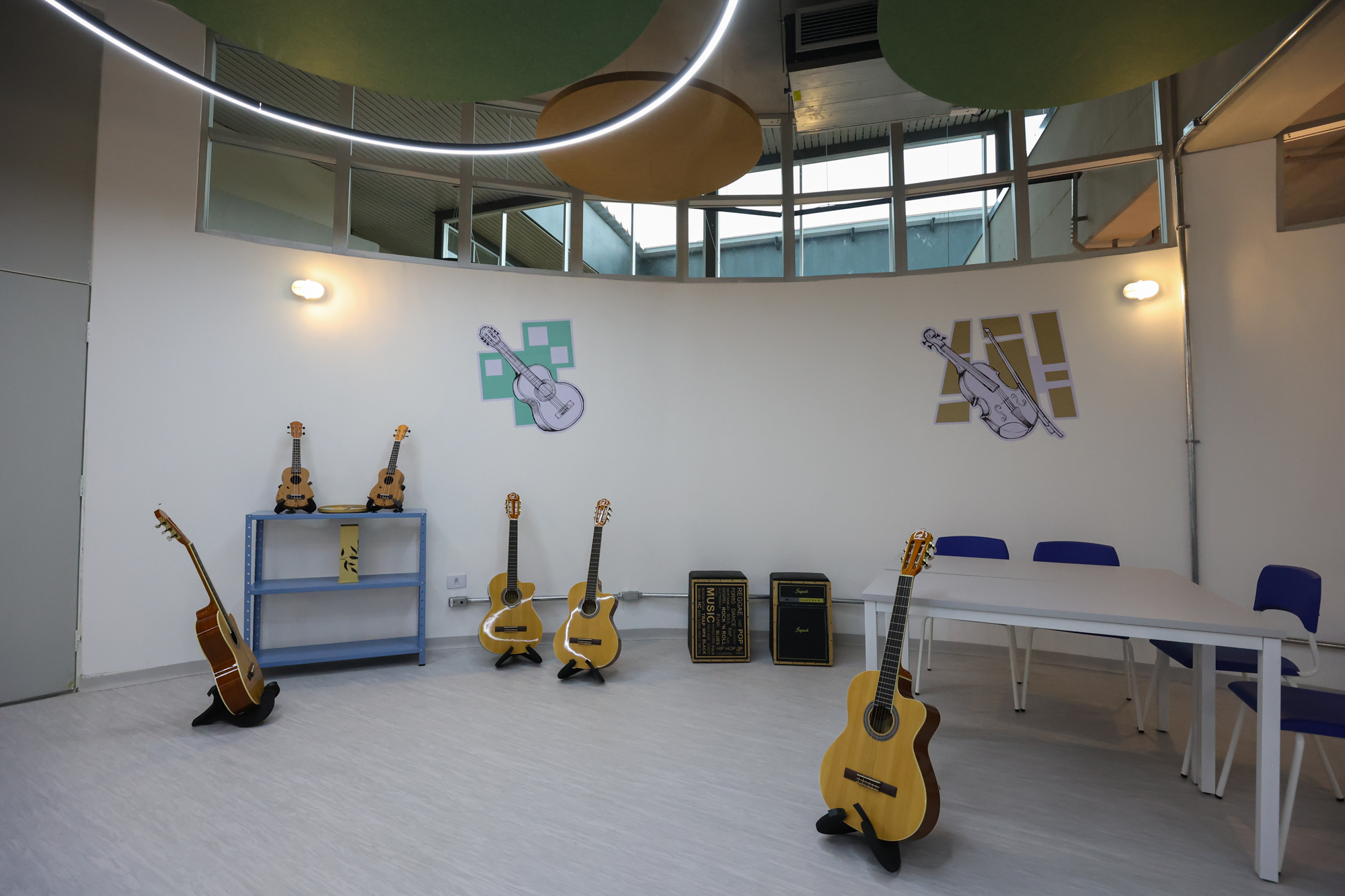 Imagem da sala de música do Centro TEA. Nela há diversos instrumentos como violão, cavaquinho, maracas. Além de tapete, mesas e cadeiras.
