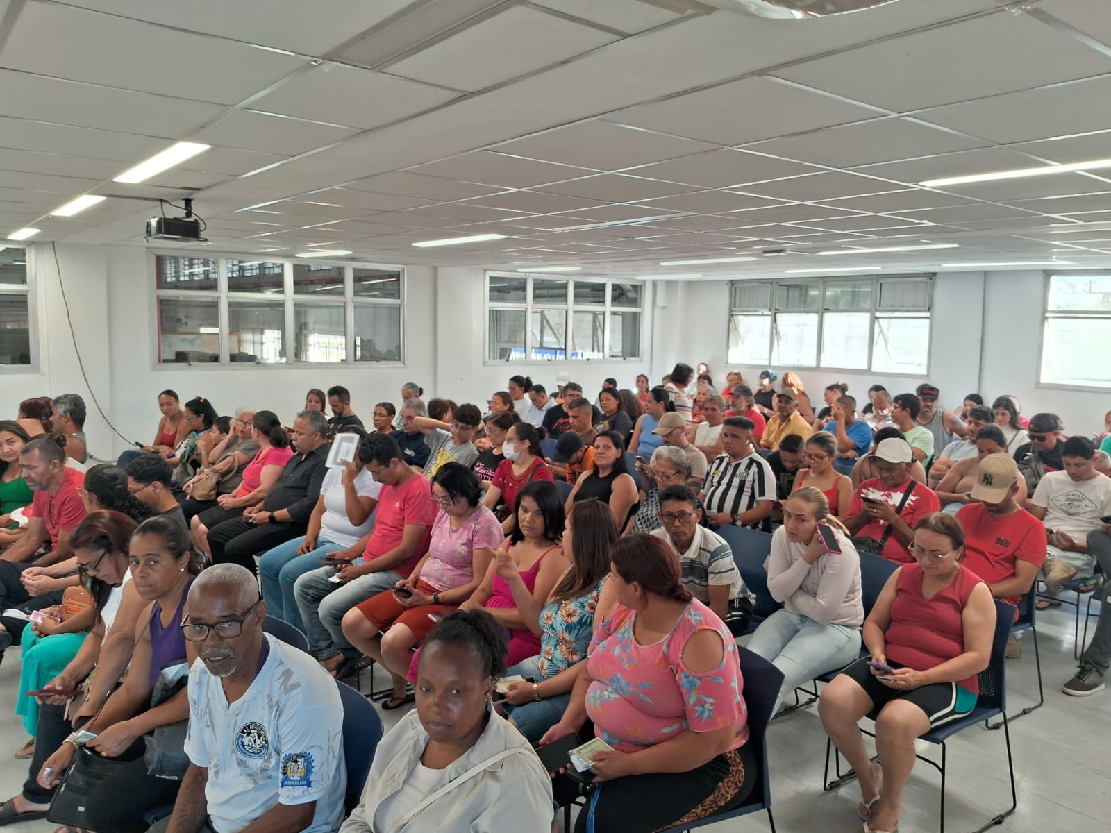 Pessoas sentadas reunidas no auditório da Subprefeitura
