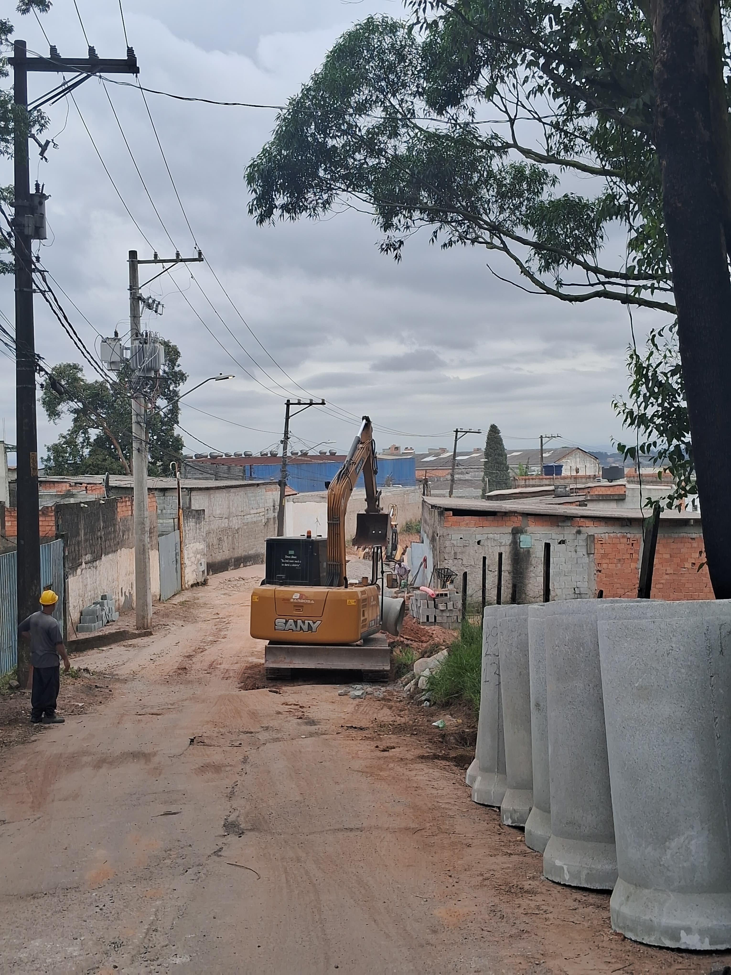Estrada de terra com escavadeira um pouco a frente