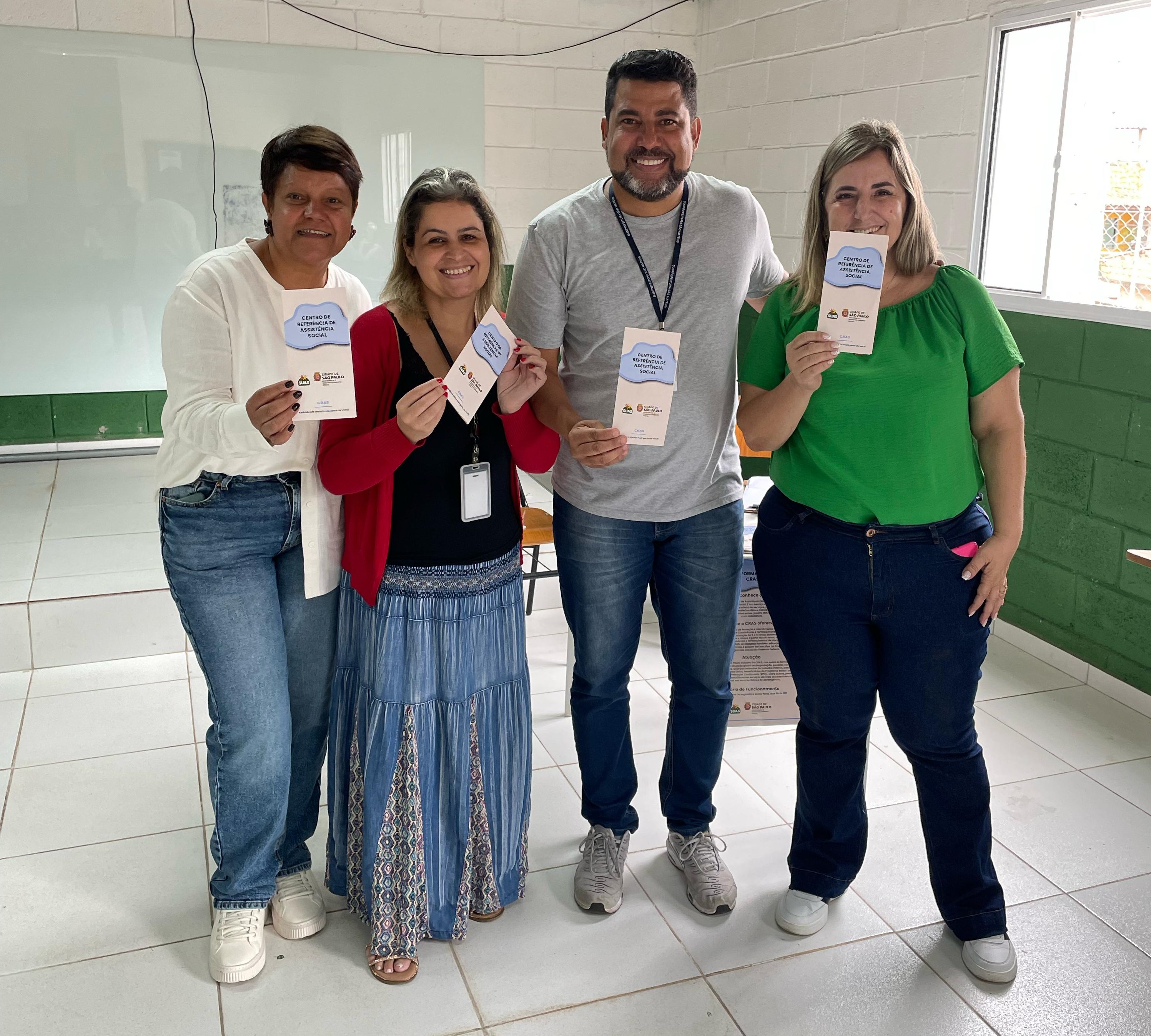 um responsável da subprefeitura são mateus com outras três municipes com um flyer de descrito 'centro de referencia de assistencia social'
