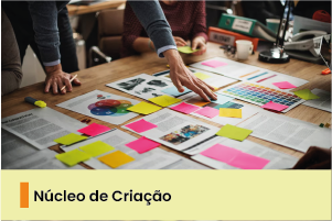 A imagem mostra uma mesa com documentos e papéis coloridos. 
