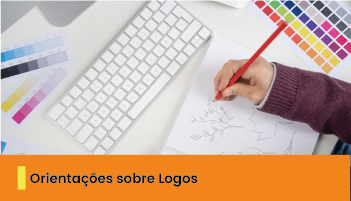 A imagem mostra uma pessoa desenhando, ao lado de papéis com cores e um teclado. 