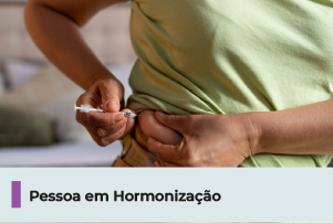 A imagem mostra pessoa realizando autoaplicação com seringa. Abaixo, uma faixa com texto 