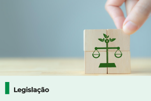 A imagem mostra blocos de madeira com o símbolo de uma balança de justiça em verde. Abaixo, uma faixa com o texto 