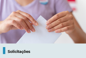 A imagem mostra uma pessoa segurando papel dobrado. Abaixo, uma faixa com o texto 