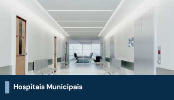 A imagem mostra um ambiente hospitalar, composto por cadeiras de espera em um corredor com paredes brancas. Há uma faixa na imagem descrito 