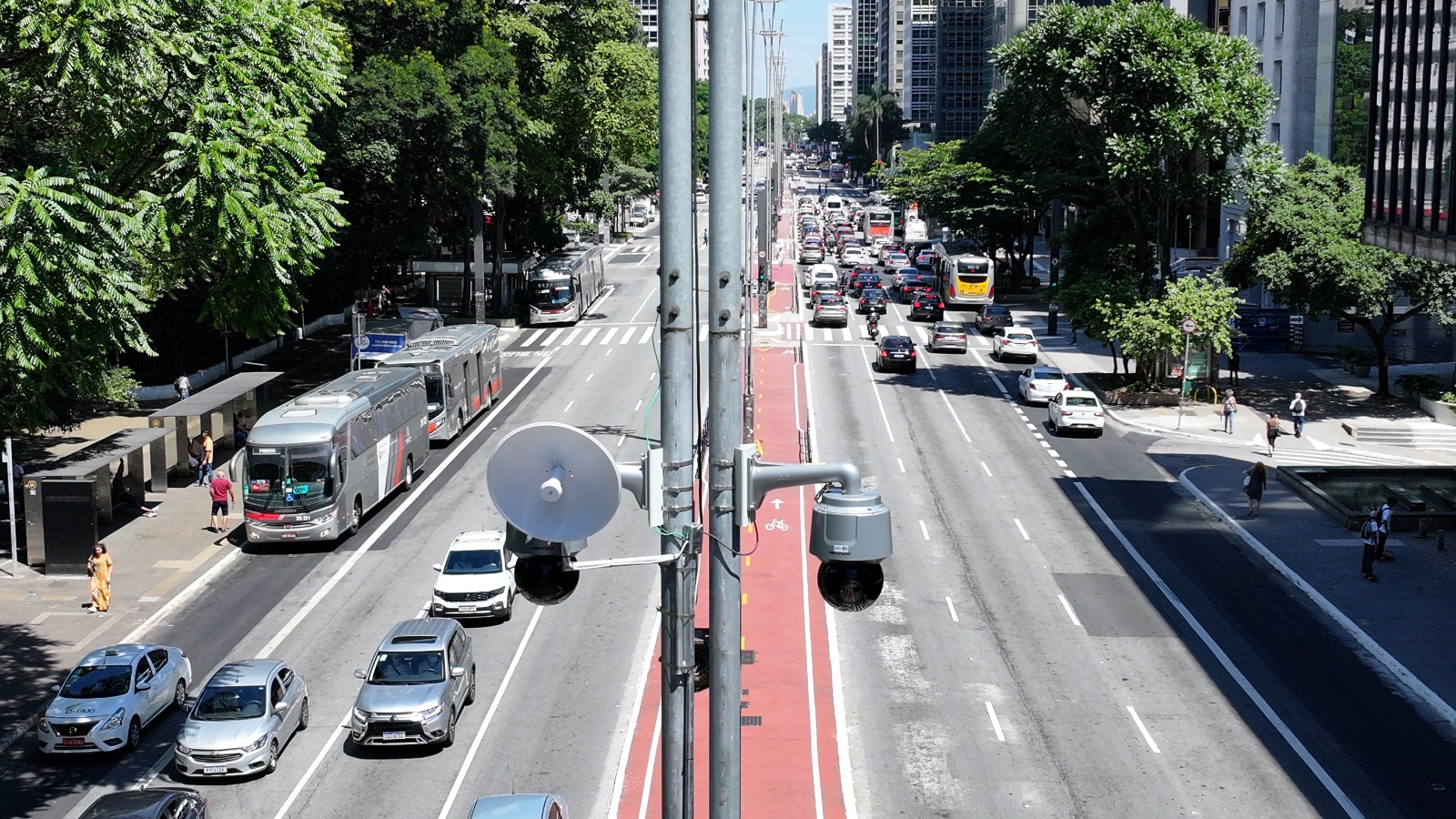 A imagem mostra veículos em movimento na avenida Paulista e destaca as câmeras do Smart Sampa