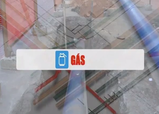 A imagem é uma composição com elementos sobrepostos. No centro, uma faixa retangular branca com bordas azuis se destaca. No lado esquerdo dessa faixa, há um ícone azul de um botijão de gás. À direita do ícone, a palavra "GÁS" é exibida em letras maiúsculas e vermelhas. O fundo da imagem é uma mistura desfocada e semi-transparente, com texturas que lembram concreto ou superfícies de construção. É possível discernir o que parecem ser tubulações ou canos em tons de azul e vermelho, além de linhas que sugerem um diagrama ou projeto. Há também elementos que lembram vergalhões ou barras de metal, e o canto superior esquerdo apresenta uma área com tom avermelhado e linhas diagonais. O efeito geral é de múltiplas camadas visuais.